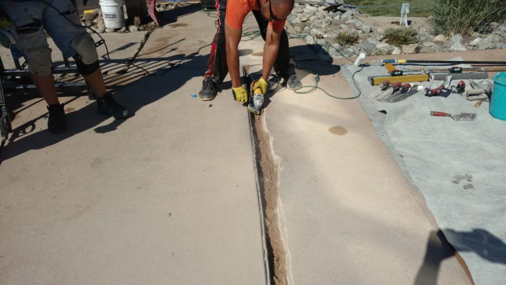 We Do Lines - A man is working on a concrete slab.
