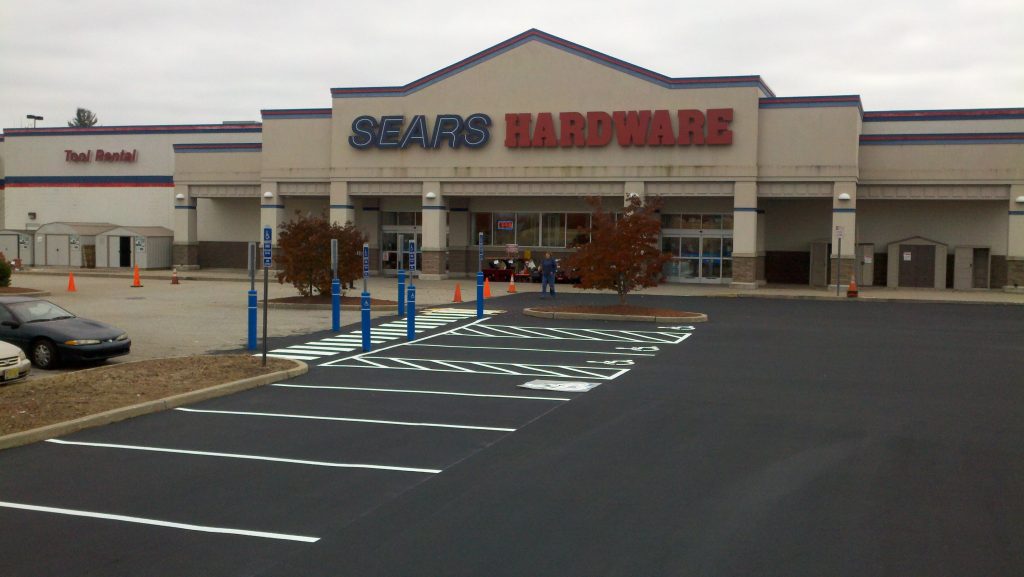 We Do Lines - A parking lot with a sears hardware store.