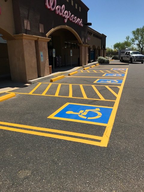 We Do Lines - A parking lot with a handicap sign painted on it.