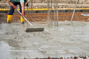 We Do Lines - A man pouring concrete on a construction site.