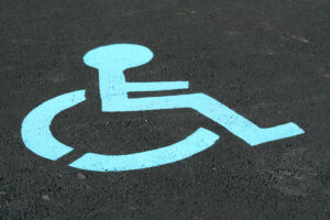 We Do Lines - A blue handicap sign is painted on the pavement.