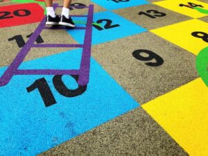 We Do Lines - A child is standing on a colorful playground.