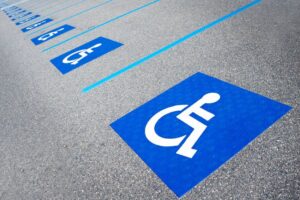Photo of a parking lot with blue markings and a wheelchair symbol