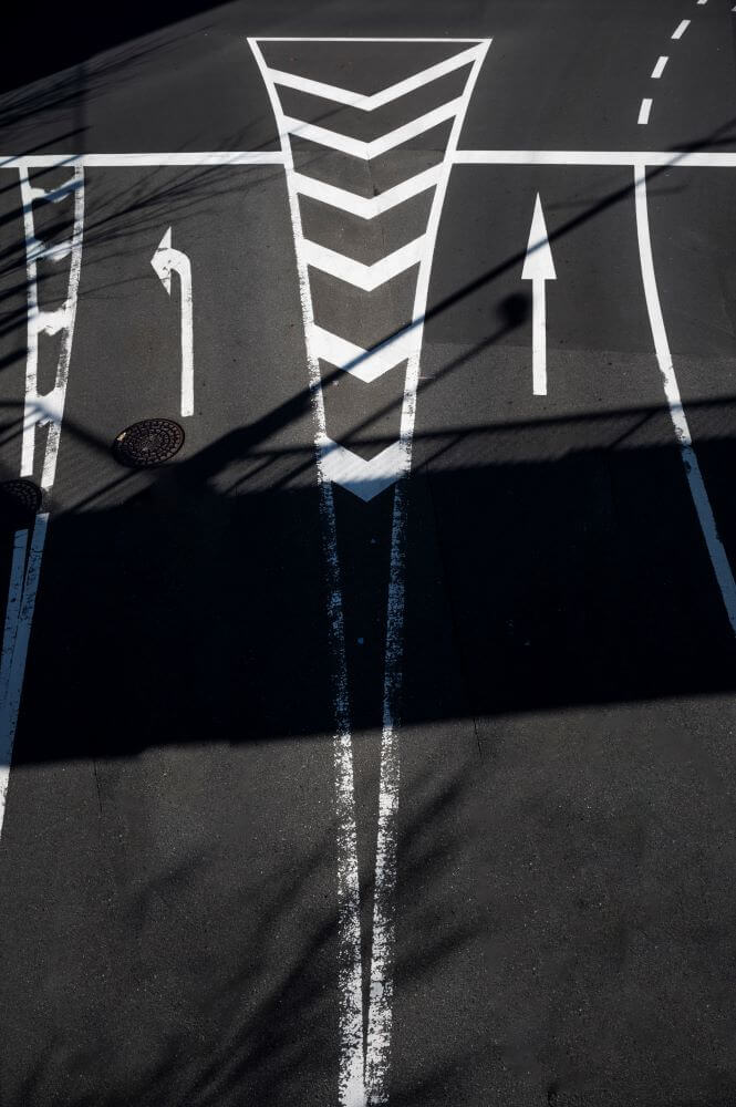 Photo of a road with a variety of signages on the road surface