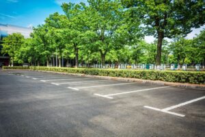 photo of an empty parking lot with divider lines on the tarmac