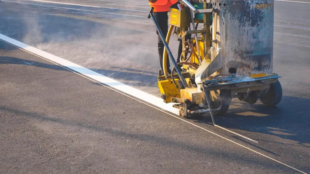 Photo of a road worker operating a line marker machine
